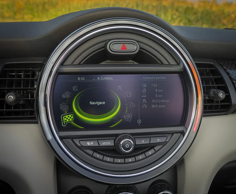 Round dashboard infotainment display showing a menu and trip information