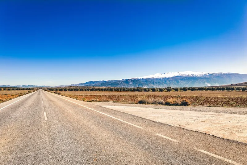 Empty road in open country under a clear blue sky