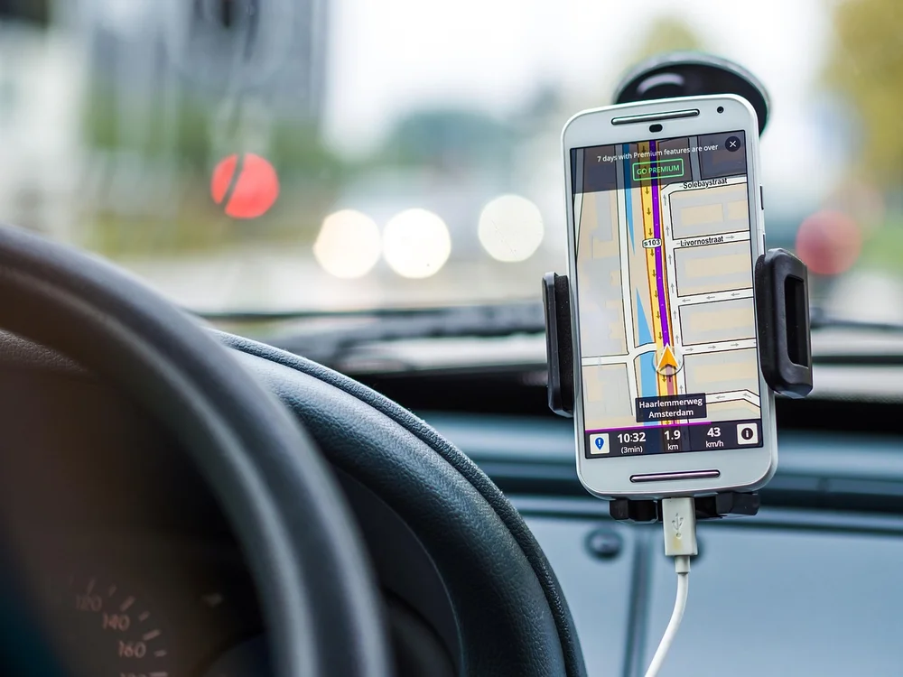 Smartphone mounted on a car dashboard showing a navigation app