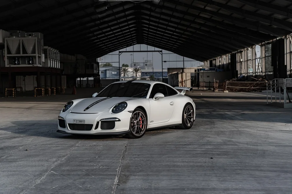 White Porsche 911 GT3 sports car parked in a warehouse