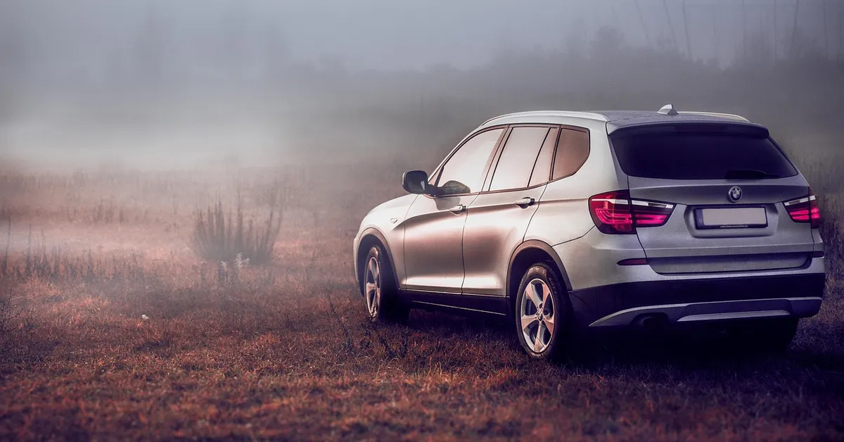 BMW X3 SUV rear three-quarter view in foggy field