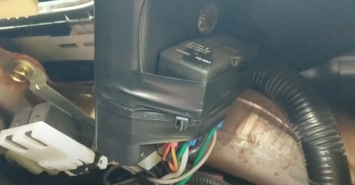Alarm relay module and wiring harness under a car dashboard