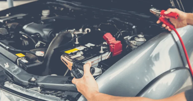 Jumper cables connected to a car battery under the hood