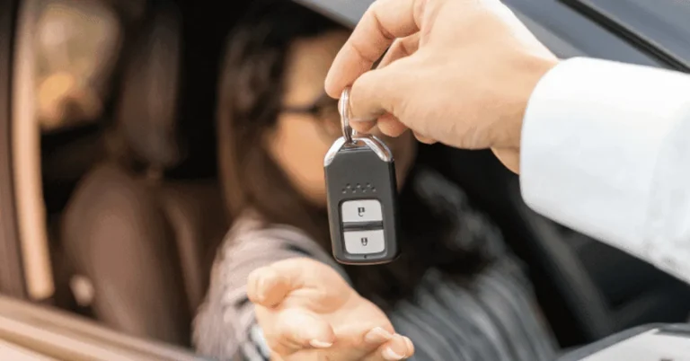 Dealer handing car keys to a buyer through the driver window