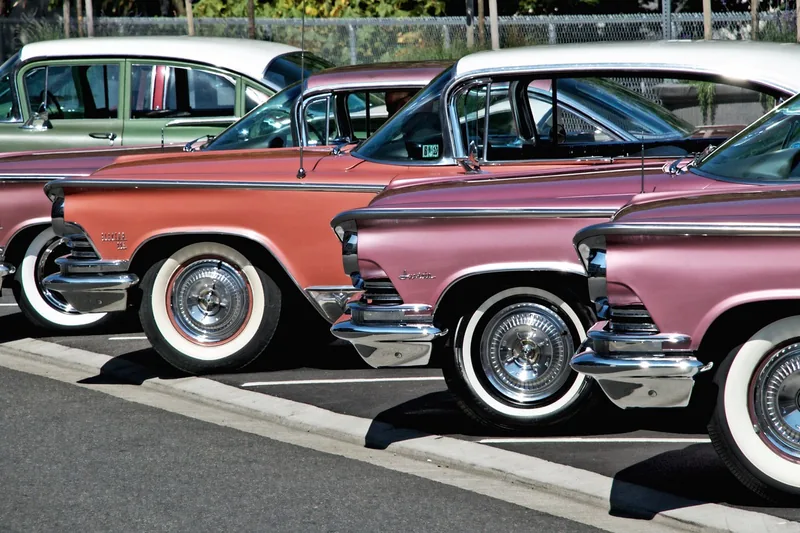 Pink and white classic American cars parked in a row