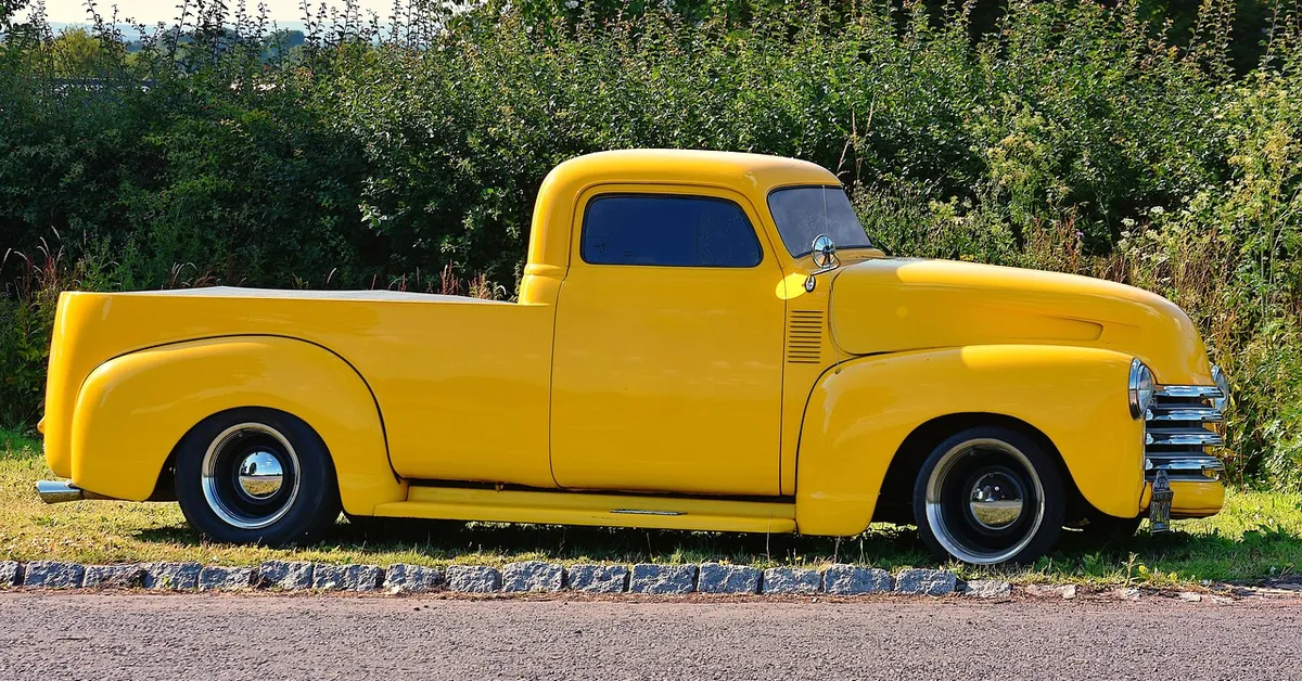 Classic yellow Chevy pickup truck parked roadside