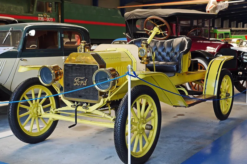 Early yellow Ford automobile on display in a museum