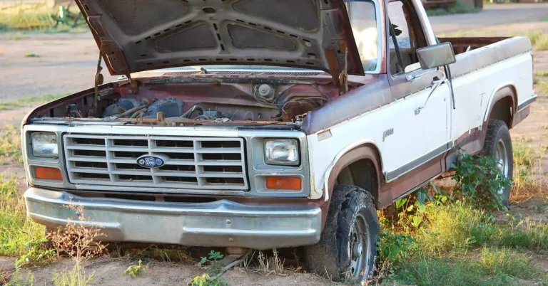 Older Ford pickup truck parked in a dirt lot with its Styleside bed visible