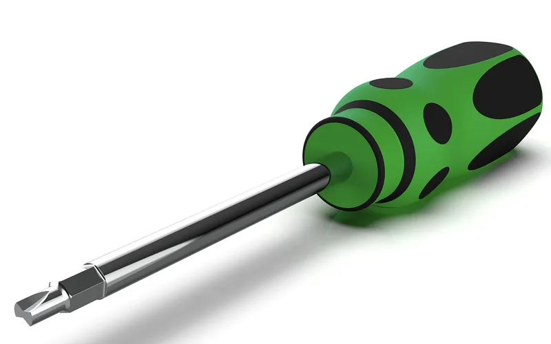 A screwdriver with a green and black handle and a bit in the shaft