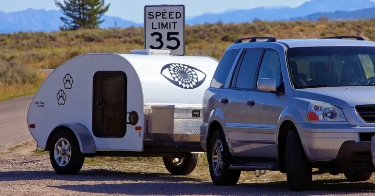 SUV towing a small teardrop camper trailer
