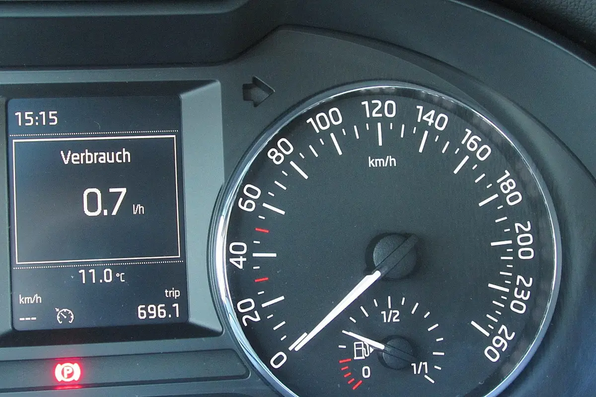 Car instrument cluster with speedometer, fuel gauge and a red parking brake indicator