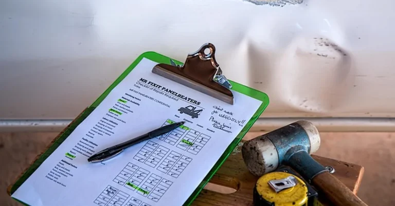 A minor dent being inspected with a repair estimate checklist, illustrating a car that keeps a clean title after a minor accident