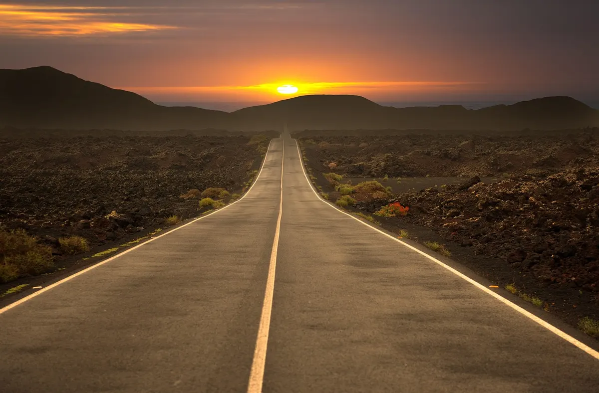 Open road at sunset stretching toward the horizon
