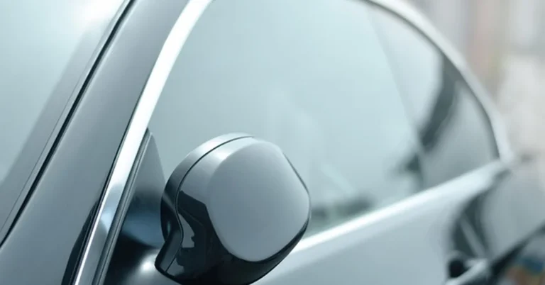 Car with dark tinted rear window, illustrating aftermarket window tinting service