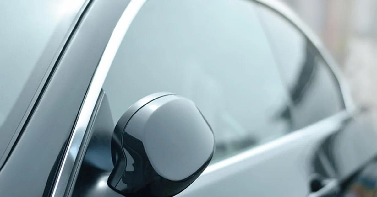 Car with dark tinted rear window, illustrating aftermarket window tinting service