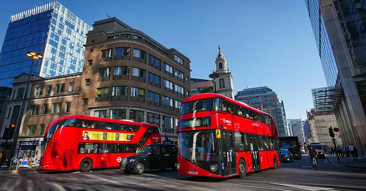 Red double-decker buses on a London street, relevant to renting a car in London as an American