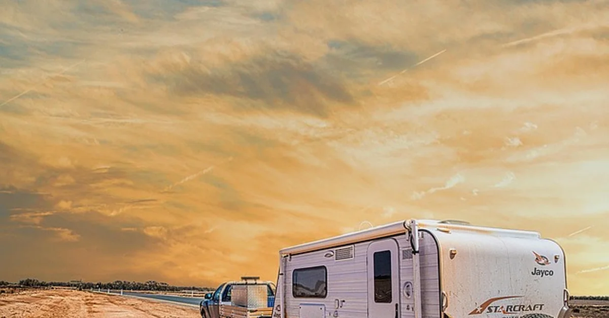 SUV towing a small camper trailer on a rural road, illustrating Ford Edge towing capacity