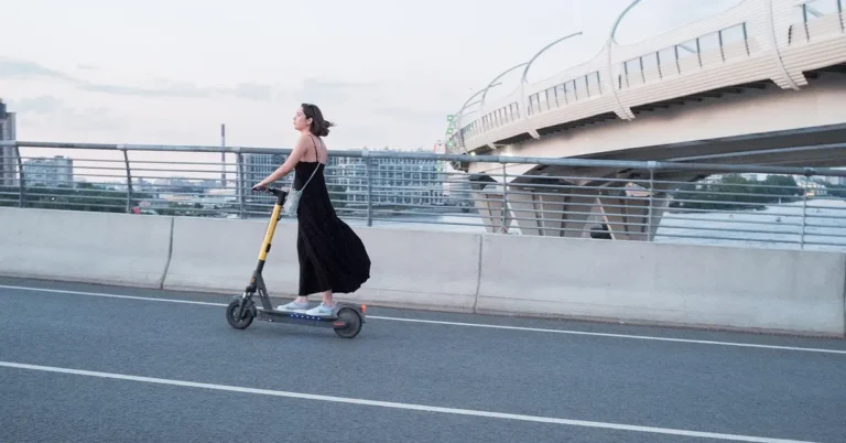 Person riding an electric scooter as alternative transportation in the city