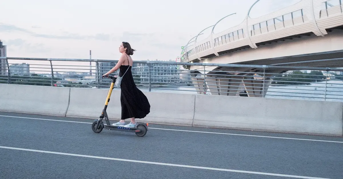 Person riding an electric scooter as alternative transportation in the city
