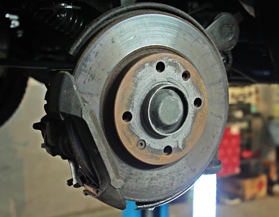 Brake disc and caliper on a vehicle in a workshop