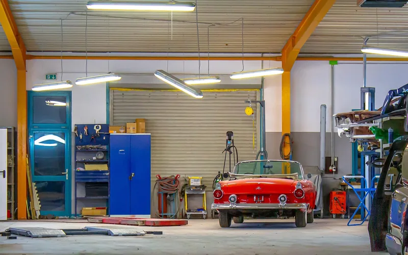 Red classic convertible parked inside a garage workshop Red classic convertible parked inside a garage workshop