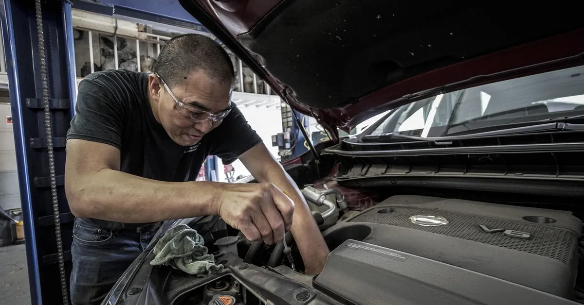 Mechanic performing engine repair at an auto shop