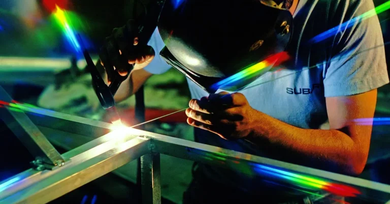 A welder working on a vehicle component, a hands-on mechanic skill
