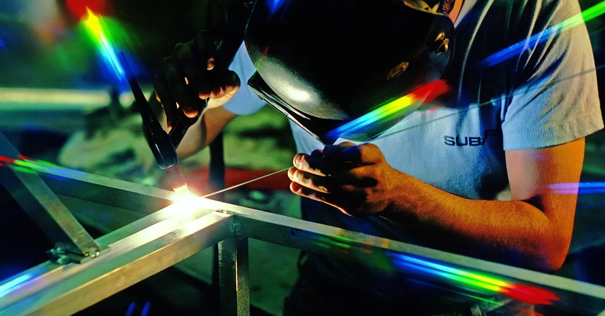 A welder working on a vehicle component, a hands-on mechanic skill