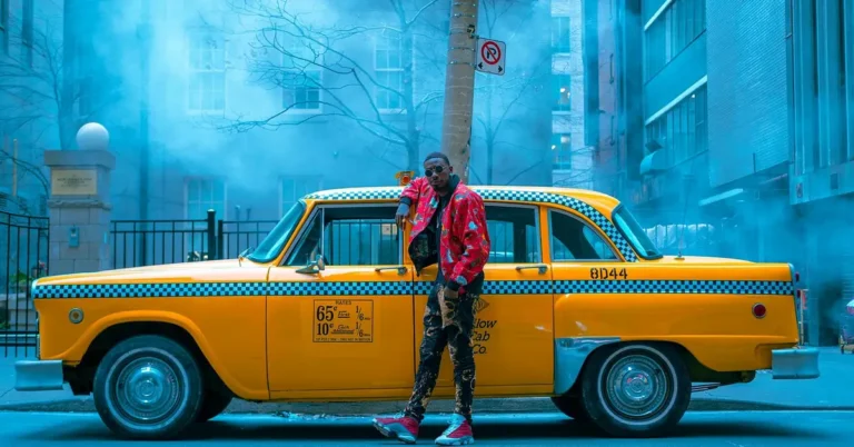 A stylish man posing with a car, representing car-inspired fashion