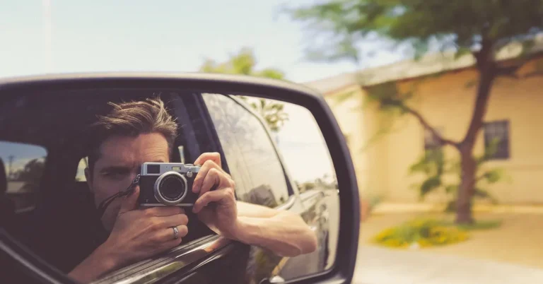 A photographer capturing a car on the road