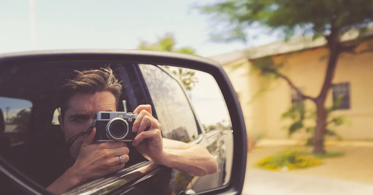 A photographer capturing a car on the road