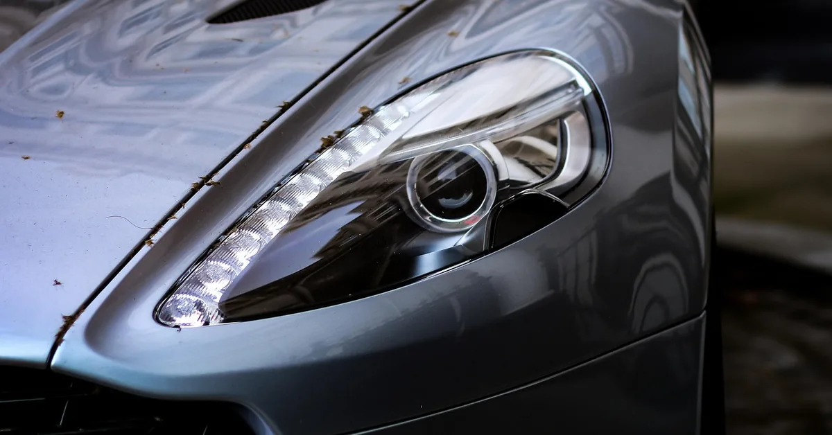Close-up of a grey sports car headlight and bonnet vent