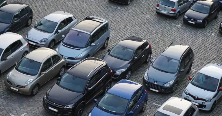 Overhead view of many different cars parked in rows on a cobblestone lot