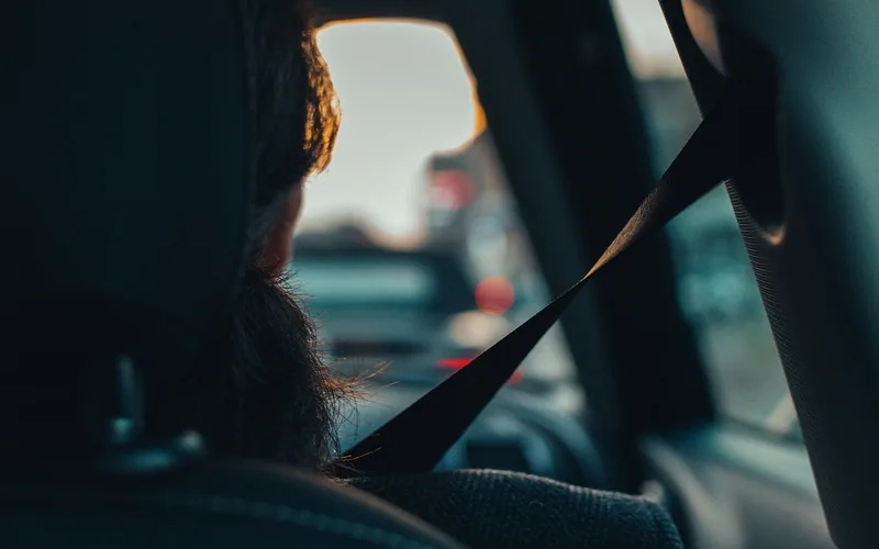 child riding in the back seat wearing a lap-and-shoulder seat belt