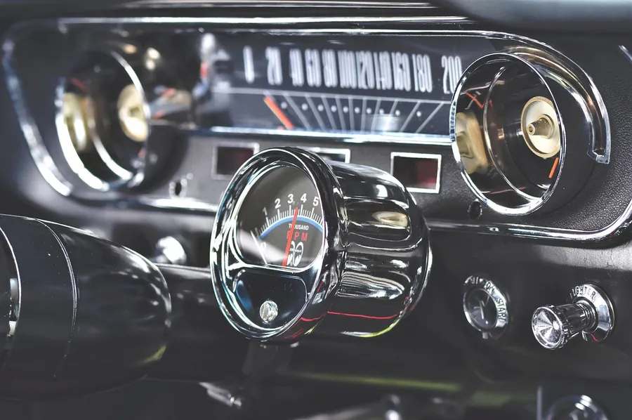 Chrome speedometer and tachometer gauges on a vintage car dashboard