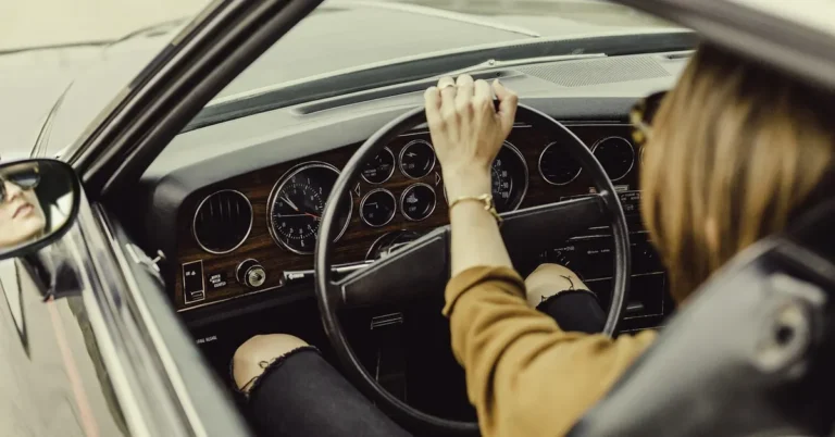 A driver using the dashboard controls of a car