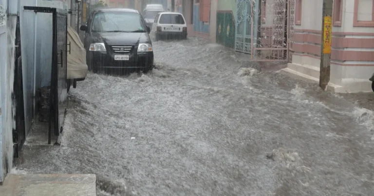 A flooded street with standing water covering a car