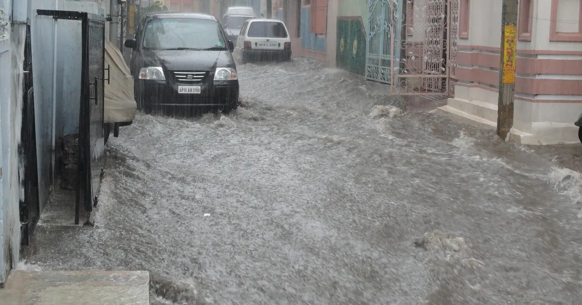 A flooded street with standing water covering a car