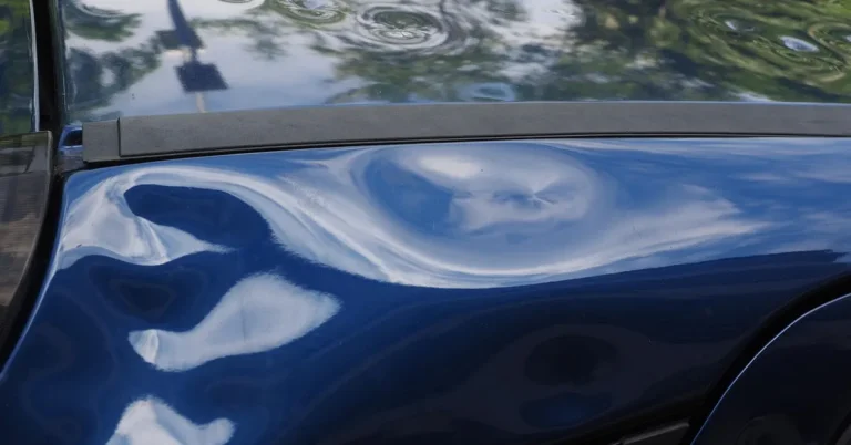Hail damage dents visible on a car roof and body panel