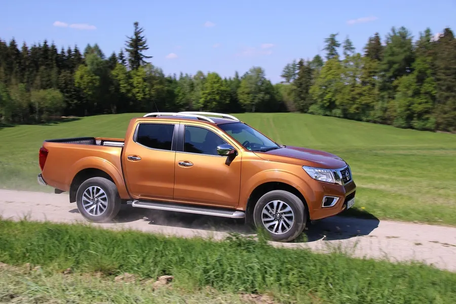 Double-cab pickup truck driving on a gravel road