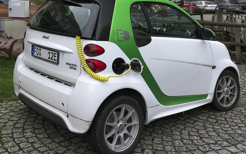 Electric vehicle plugged into a charging station showing the battery pack connection Electric vehicle plugged into a charging station showing the battery pack connection
