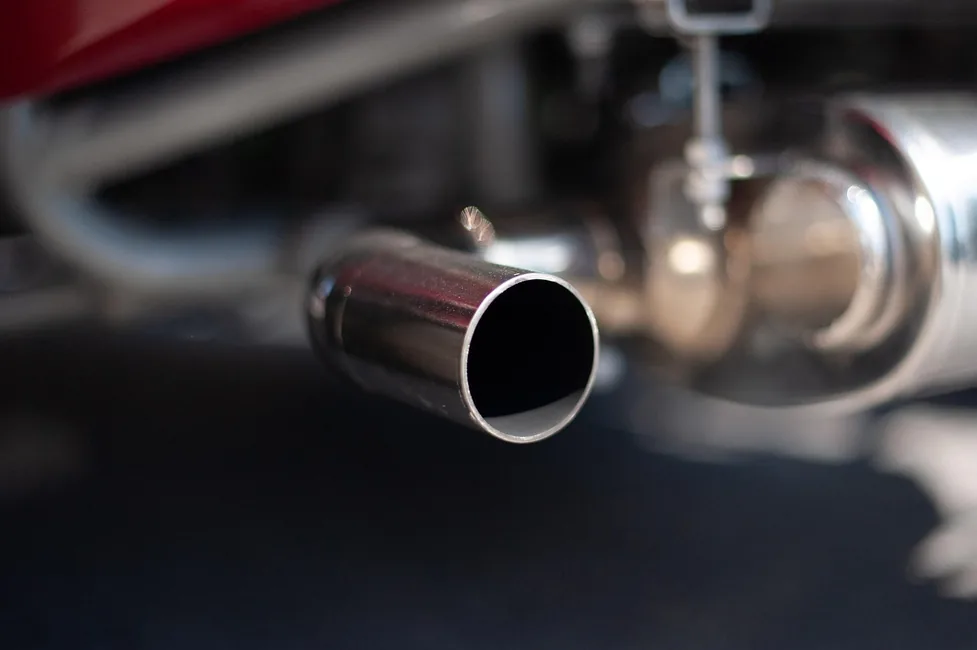 Car exhaust pipe releasing emissions from the tailpipe