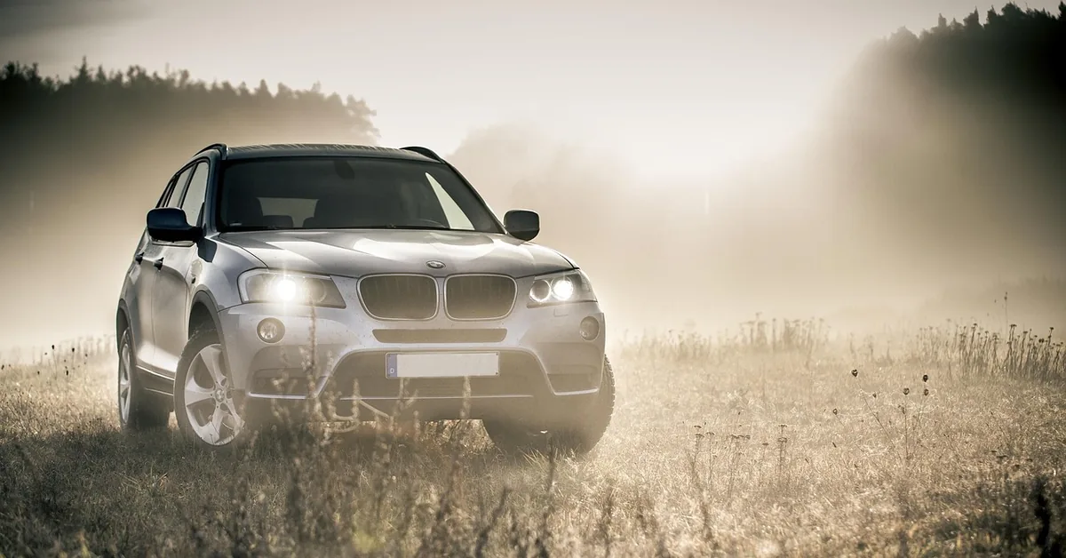 SUV parked outdoors in fog with headlights on