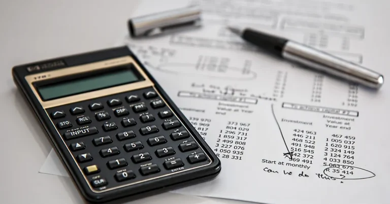 A calculator and pen used for reviewing loan finances