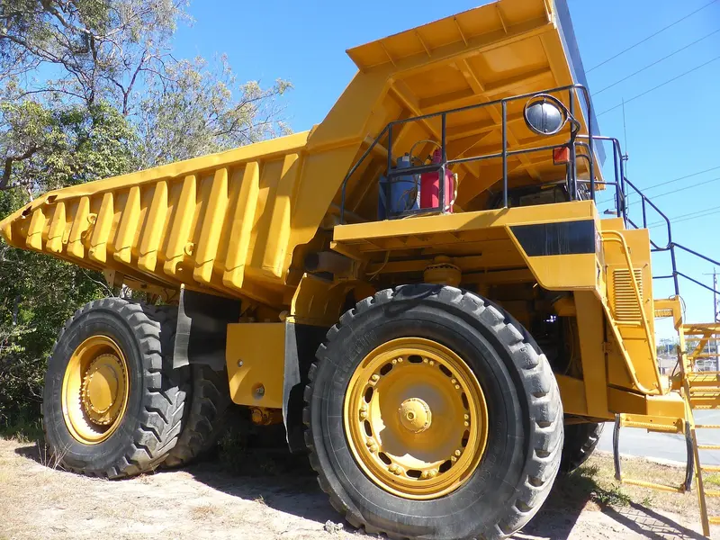 Yellow off-highway mining dump truck with its body raised
