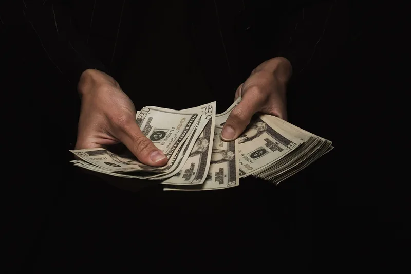 Hands counting a fan of US twenty dollar bills