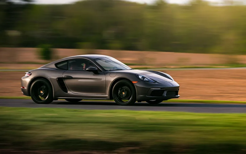 Gray two-door coupe driving fast on a country road