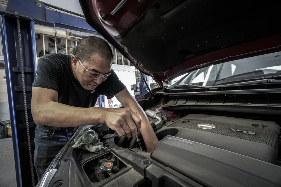Mechanic performing routine oil change service on a car