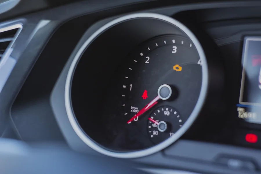 Check engine warning light lit on a car dashboard gauge cluster