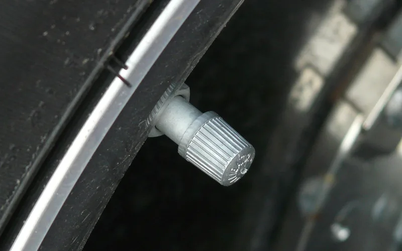 close-up of a car tire valve stem used to check and adjust tire air pressure